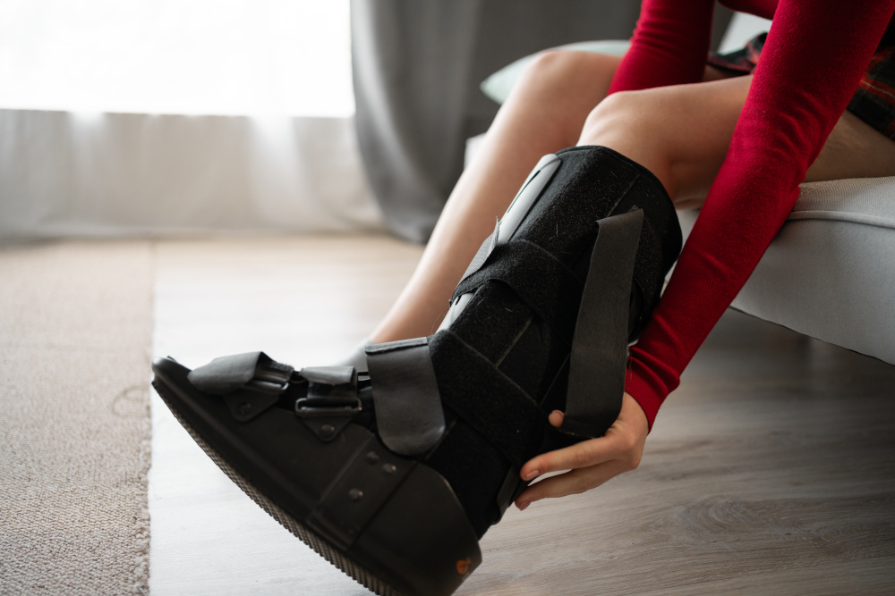 Eine Person zieht einen schwarzen, medizinischen Stiefel an.